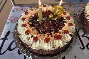 Schokoladentorte mit Sahne, Schokoladenraspeln und Kerzen für den 13. Geburtstag.
